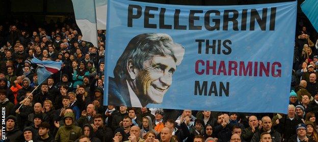 Manchester City fans hold aloft a banner for Manuel Pellegrini