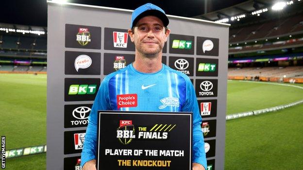 Adelaide Strikers batter Ian Cockbain holds up a sign as player of the match after victory over Sydney Thunder