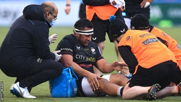 Mako Vunipola receives treatment on the pitch during Saracens' match with Leicester