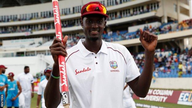 West Indies captain Jason Holder holds up a stump in celebration after beating England in the second Test