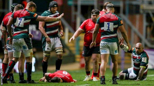 John Cooney of Ulster lies injured after being caught by Nemani Nadolo of Leicester Tigers, right, before leaving the pitch for a HIA during the Heineken Challenge Cup semi-final match between Leicester Tigers and Ulster at Welford Road