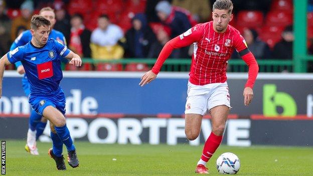 Swindon Town forward Ellis Iandolo in action against Harrogate Town