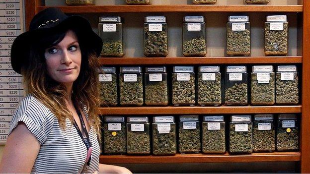 Assistant manager Jaclyn Stafford works behind the sales counter at The Station, a retail and medical cannabis dispensary, in Boulder, Colorado