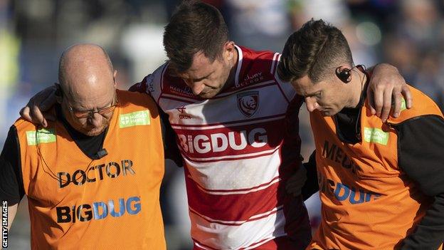 Mark Atkinson being helped off the pitch