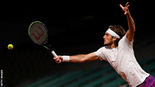 Stefanos Tsitsipas reaches to hit a ball