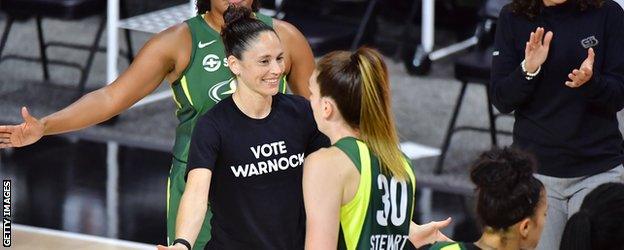 Sue Bird wearing a 'Vote Warnock' t-shirt