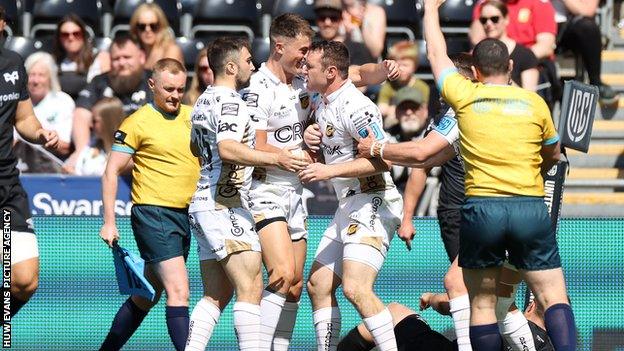 Dragons players celebrate a try from centre Adam Warren