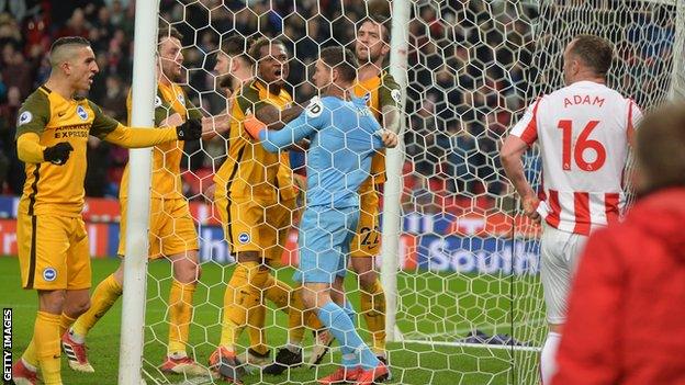 Charlie Adam looks on in dismay as Brighton goalkeeper Mat Ryan is congratulated by his team-mates for saving the Stoke midfielder's late spot-kick