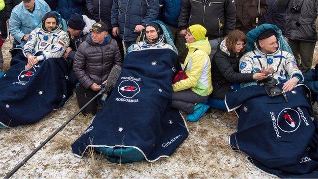 A handout photograph made available by NASA showing Russian cosmonauts Mikhail Kornienko, (L), Sergey Volkov of Roscosmos, (C), and Expedition 46 Commander Scott Kelly (R) of NASA, resting in chairs outside of the Soyuz TMA-18M spacecraft just minutes after they landed in a remote area near the town of Zhezkazgan, Kazakhstan, 02 March 2016.