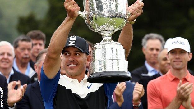 Brooks Koepka lifts the Wanamaker Trophy