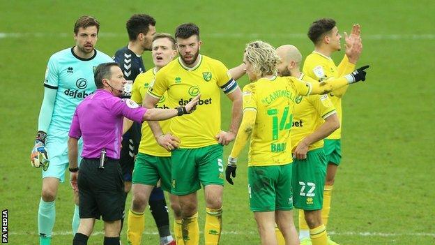 Norwich's players surrounded referee Keith Stroud following his decision to send off Emi Buendia