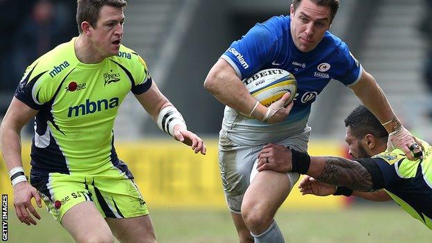 hris Wyles of Saracens breaks through the tackle of Johnny Leota