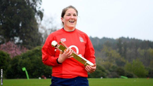 Poppy Cleall smiles with a trophy