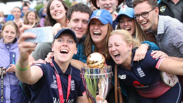 Heather Knight takes a selfie with fans and the World Cup trophy