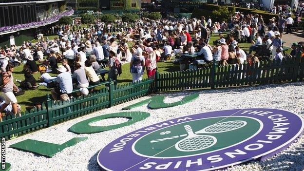 Spectators watch the TV screen on Henman Hill at Wimbledon