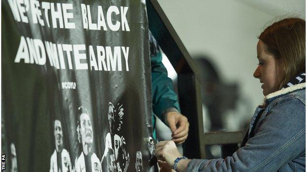 Notts County Ladies fan hangs a flag at Meadow Lane