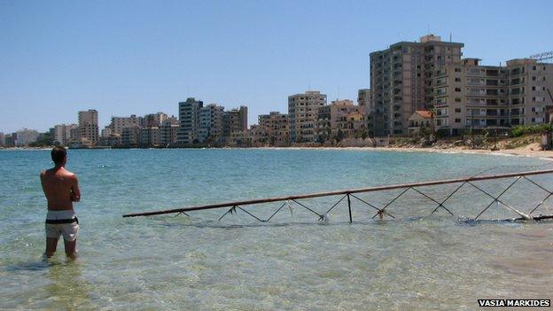 man standing in sea looks out over the ghost city