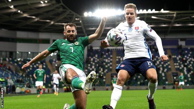 Niall McGinn and Tomas Hubocan in action during the first half at Windsor Park