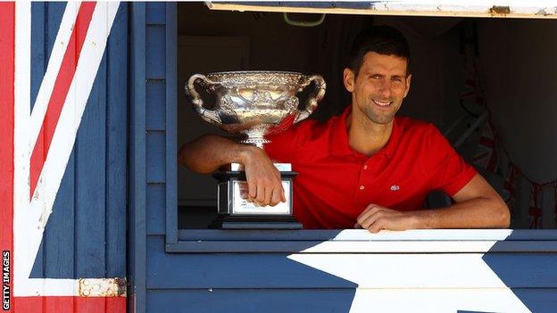 Novak Djokovic poses with the Australian Open trophy after winning the 2021 men's singles title