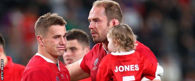 Jonathan Davies is consoled by Alun Wyn Jones, who holds his young daughter Efa in his arms