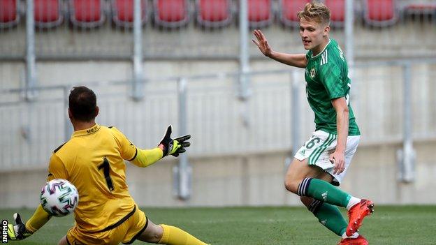 Ali McCann lifts the ball over keeper Henry Bonello to score Northern Ireland's third goal