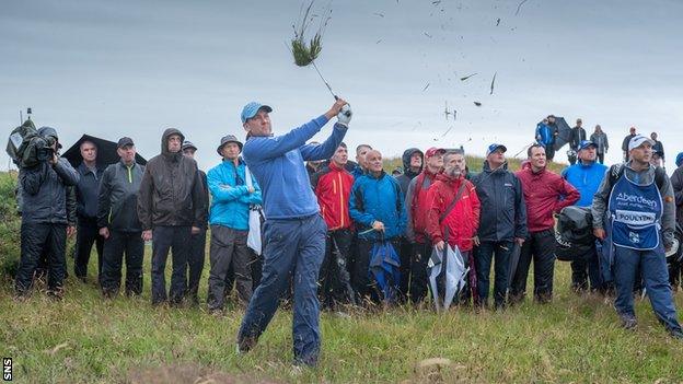 Ian Poulter lashes one out of the rough at rain-lashed Dundonald Links