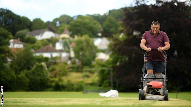 Groundsman at Uplyme and Lyme Regis cricket club prepares the square