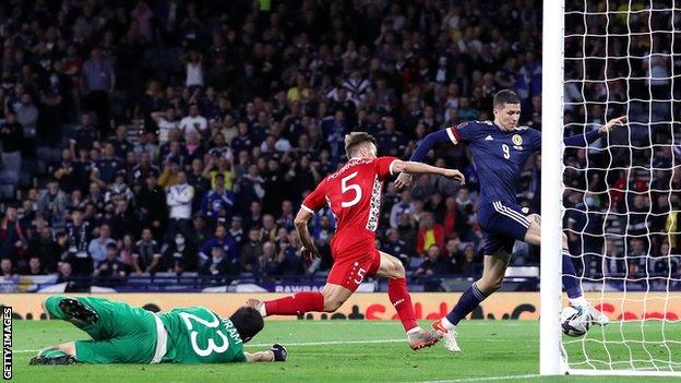 Scotland striker Lyndon Dykes scores