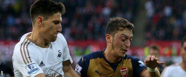 Arsenal's Mesut Ozil (right) battles with Swansea's Federico Fernandez