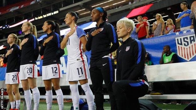 Megan Rapinoe kneels for the US national anthem