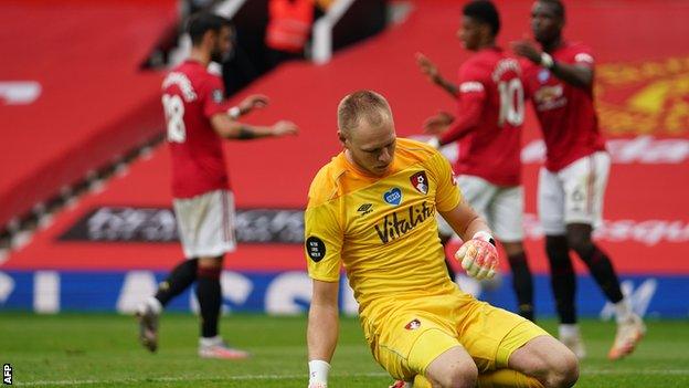 Bournemouth player looks dejected as Manchester United celebrate in the background