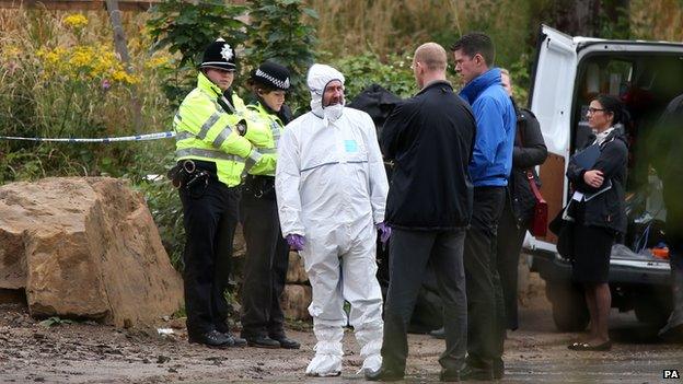 Police at a muddy construction site