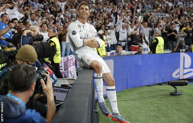 Cristiano Ronaldo sits on the advertising boards by the pitch after scoring for Real Madrid against Atletico Madrid in the 2017 semi-finals