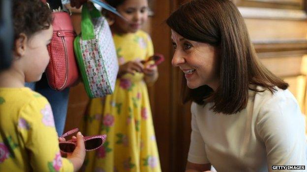 Liz Kendall talks to a young girl before a campaign visit