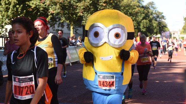 A runner in a costume finishing the Cardiff Half Marathon