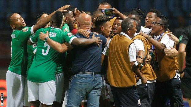 Madagascar players celebrate with the coaching staff as they score their first Africa Cup of Nations goal