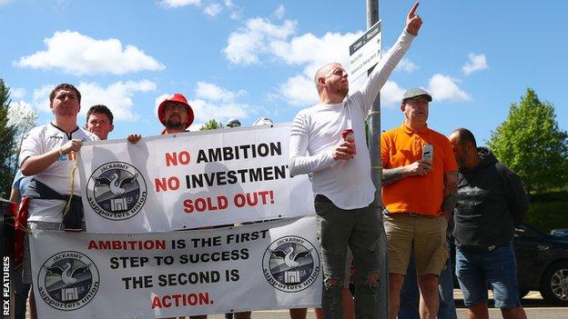 Swansea City supporters protest following the club's relegation from the Premier League