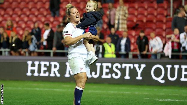 Marlie Packer holding her son Oliver after a game