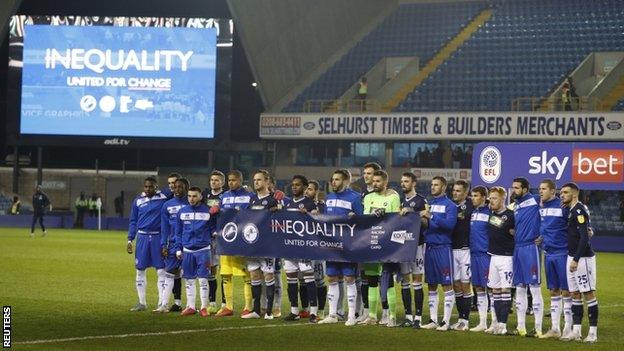 Millwall and QPR players holding an anti-racism banner before their game on 8 December 2020