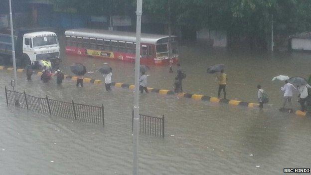 Waterlogged roads have brought traffic to a standstill forcing many to brave the rains on foot