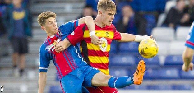 Caley Thistle's Ryan Christie is held off by Thistle's Liam Lindsay