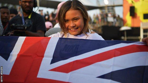 Sky Brown smiling as she holds a union flag