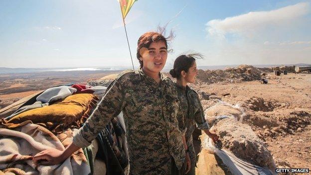 Women fighters from a Kurdish People's Protection Unit at a check point on the outskirts of the destroyed Syrian town of Kobane