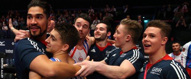 Louis Smith gives team-mate MAx Whitlock a hug as GB celebrate their silver medal