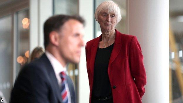 FA head of women's Baroness Sue Campbell watches Phil Neville speak to the media