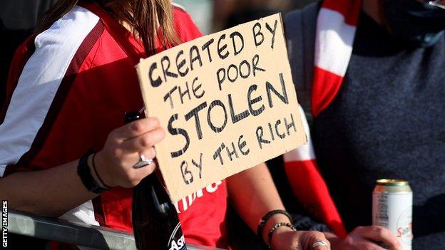 A protest sign outside Arsenal's Emirates Stadium