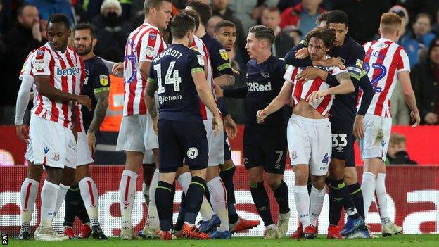 Joe Allen is pulled away by Derby defender Curtis Davies following a melee between the two sides