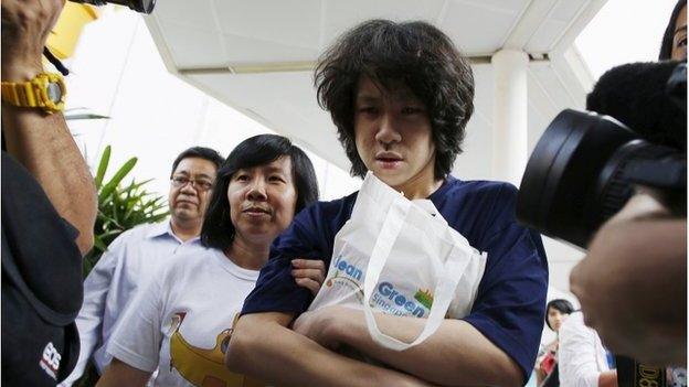 Teen blogger Amos Yee leaves with his parents after his sentencing, from the State Courts in Singapore 6 July 2015