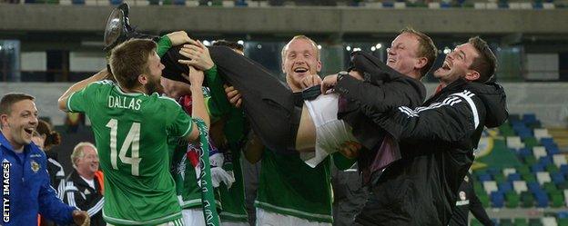 Michael O'Neill is held aloft by Northern Ireland players