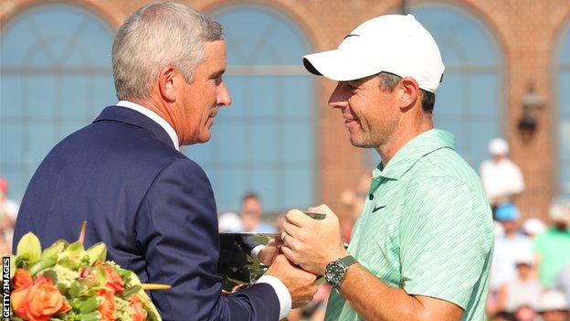 McIlroy (left) receives the FedEx Cup from PGA Tour commissioner Tim Finchem